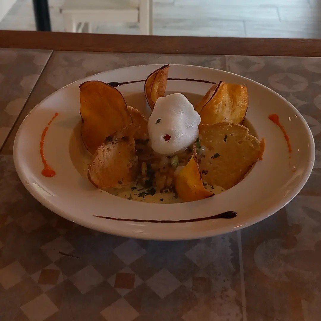 Prato branco com lascas finas estaladiças à volta e uma espuma branca no centro